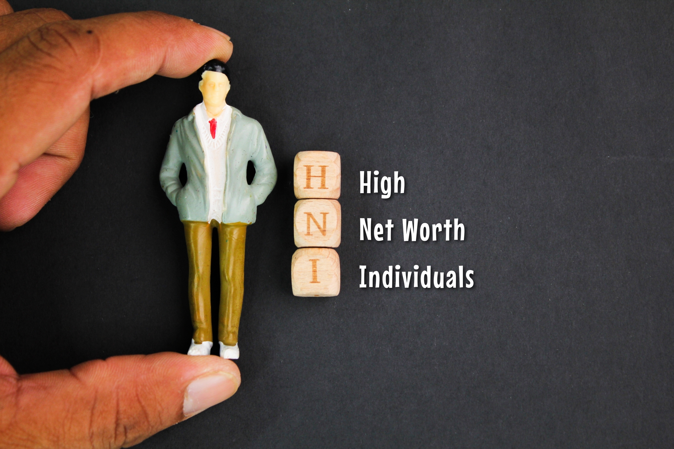 miniatures of people and sticks with the words High Net Worth Individuals. the concept of the value of a person's property or assets