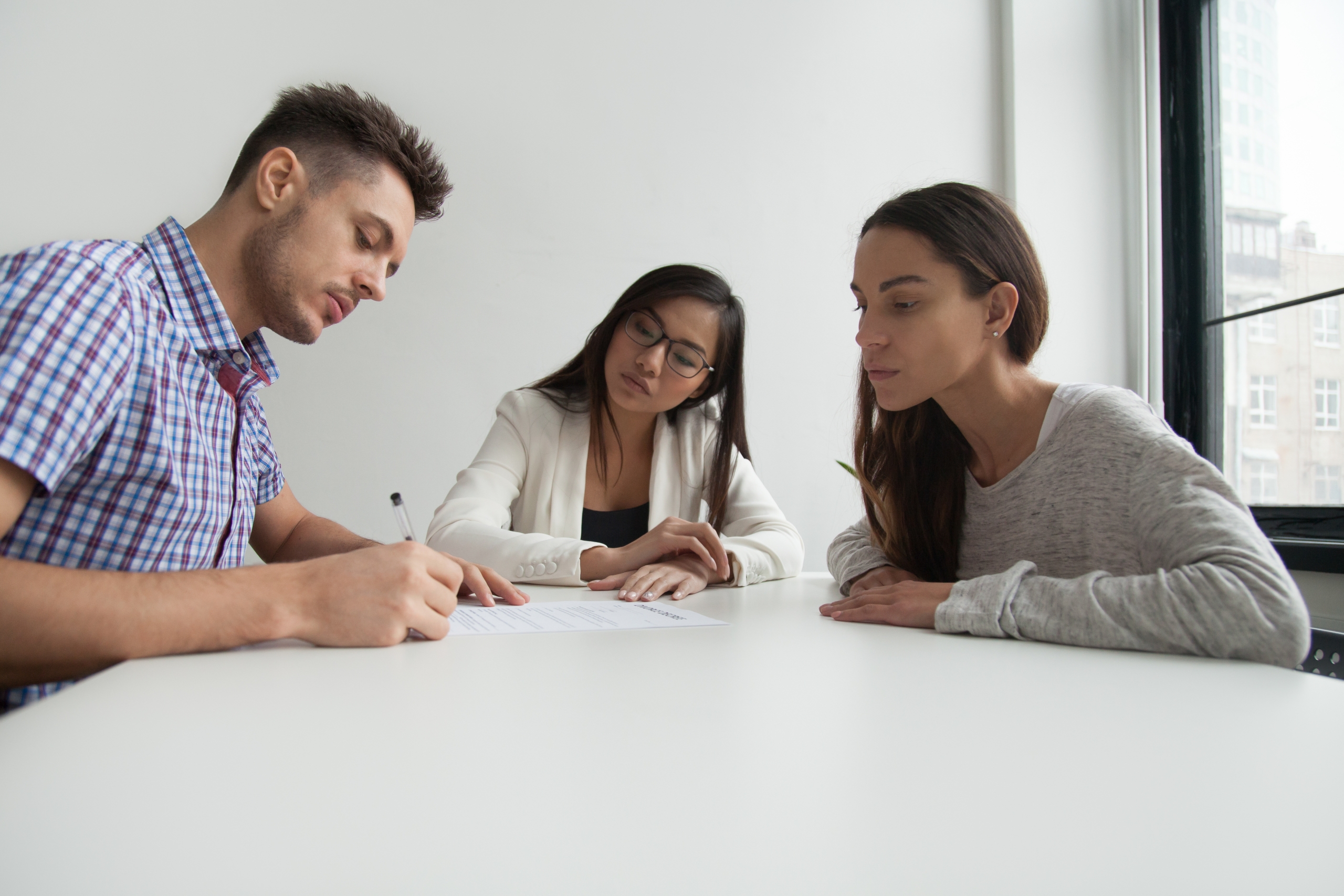 Upset husband signing divorce settlement Why a one lawyer one couple divorce might be good for you