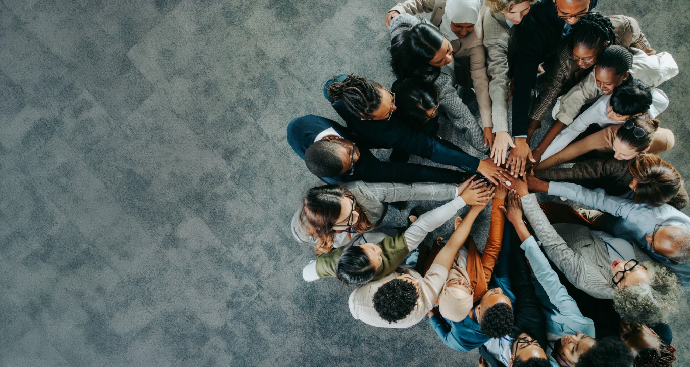 Diverse business team uniting with hands together in a show of teamwork and collaboration The trusted professionals working at OLS Solicitors